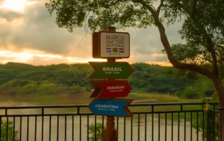 Señal en el mirador de las Tres Fronteras indicando Brasil, Paraguay y Argentina junto a un río, representando la conexión comercial entre Europa y Mercosur.